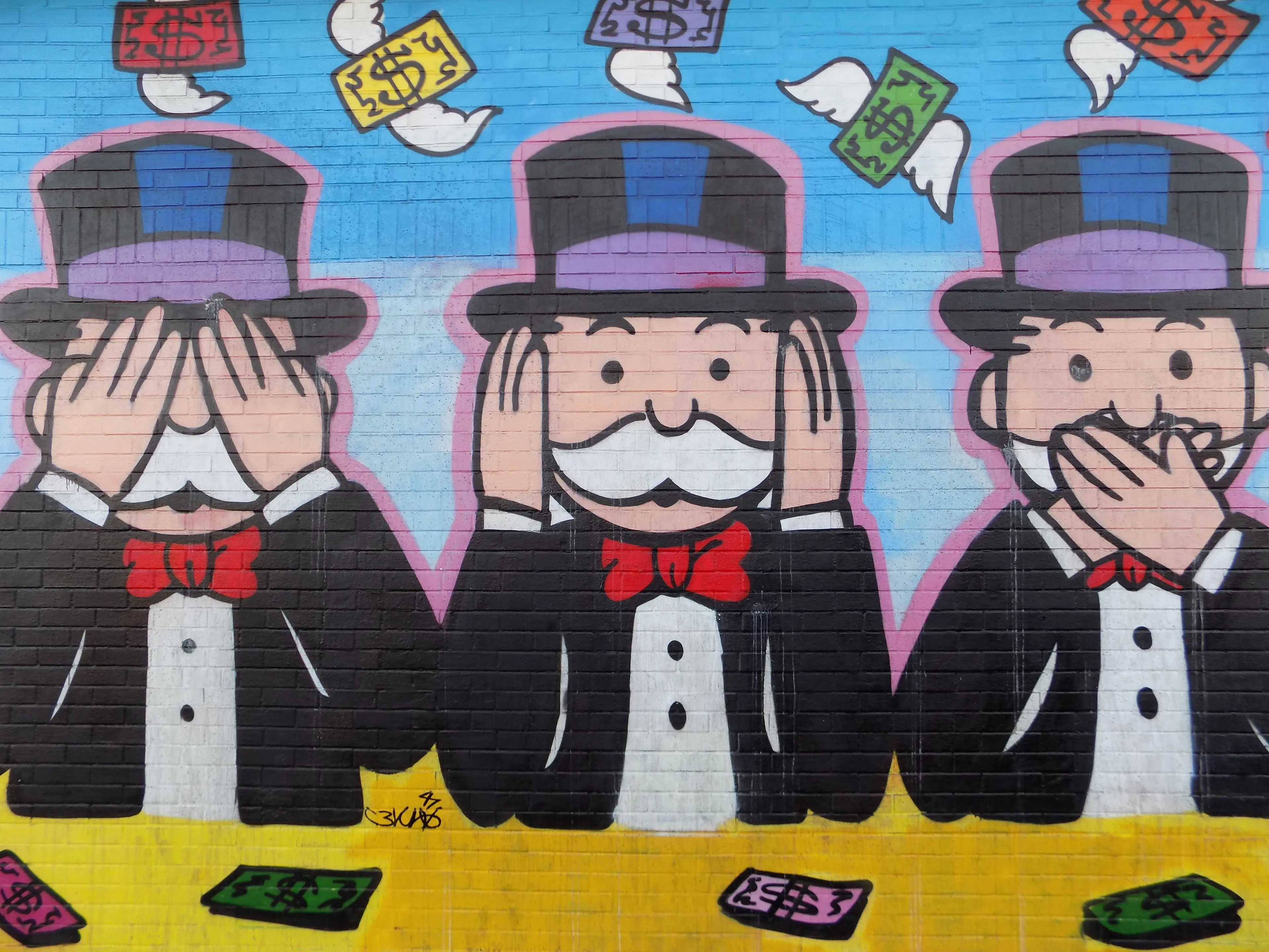 Graffiti of the Monopoly man doing the see no evil, hear no evil, speak no evil monkey faces.